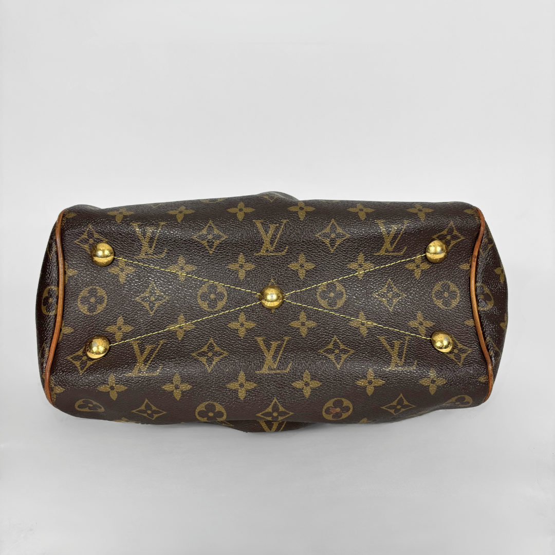 Braune Handtasche mit goldenen Akzenten auf weißem Hintergrund