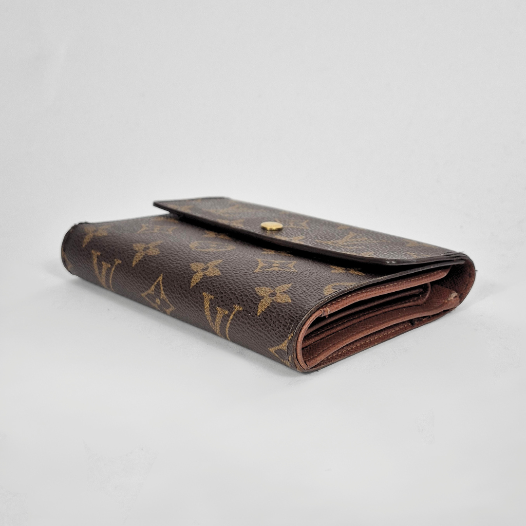 Cartera marrón con estampado de monograma dorado sobre fondo gris claro