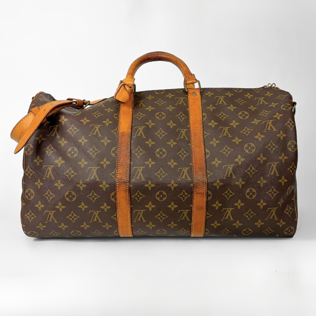 Reisetasche mit braunem Monogrammmuster, hellbraunen Ledergriffen und -riemen auf weißem Hintergrund