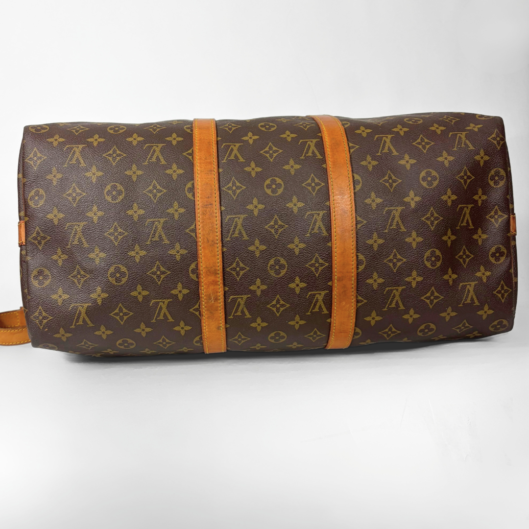 Braune Reisetasche mit Monogrammmuster auf weißem Hintergrund