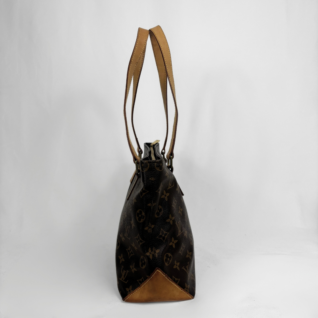 A Louis Vuitton monogram bucket bag in dark brown coated canvas with tan leather trim and shoulder straps, shown against a plain light gray background.