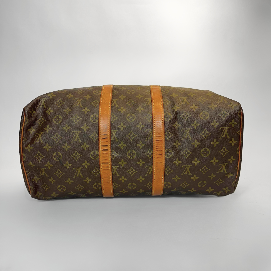 Brown travel bag with orange straps on a gray background