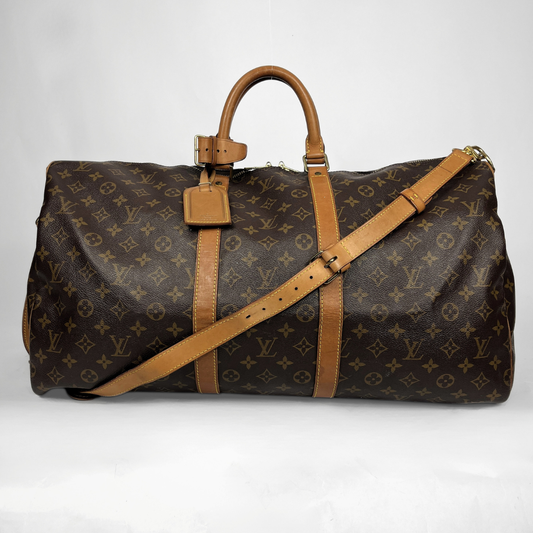 A Louis Vuitton monogram canvas duffel bag with tan leather handles, trim, and a matching shoulder strap, photographed against a plain light background.