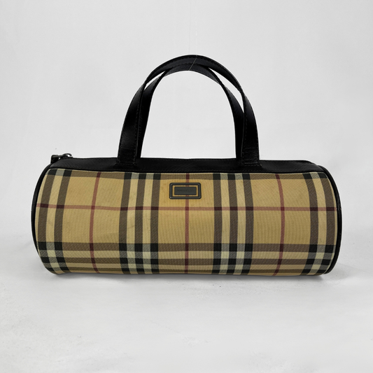 Burberry Die Mini Barrel Handtasche aus dem ikonischen beigen House Check Canvas mit braunen Lederbesätzen und -details wird auf hellgrauem Hintergrund präsentiert.