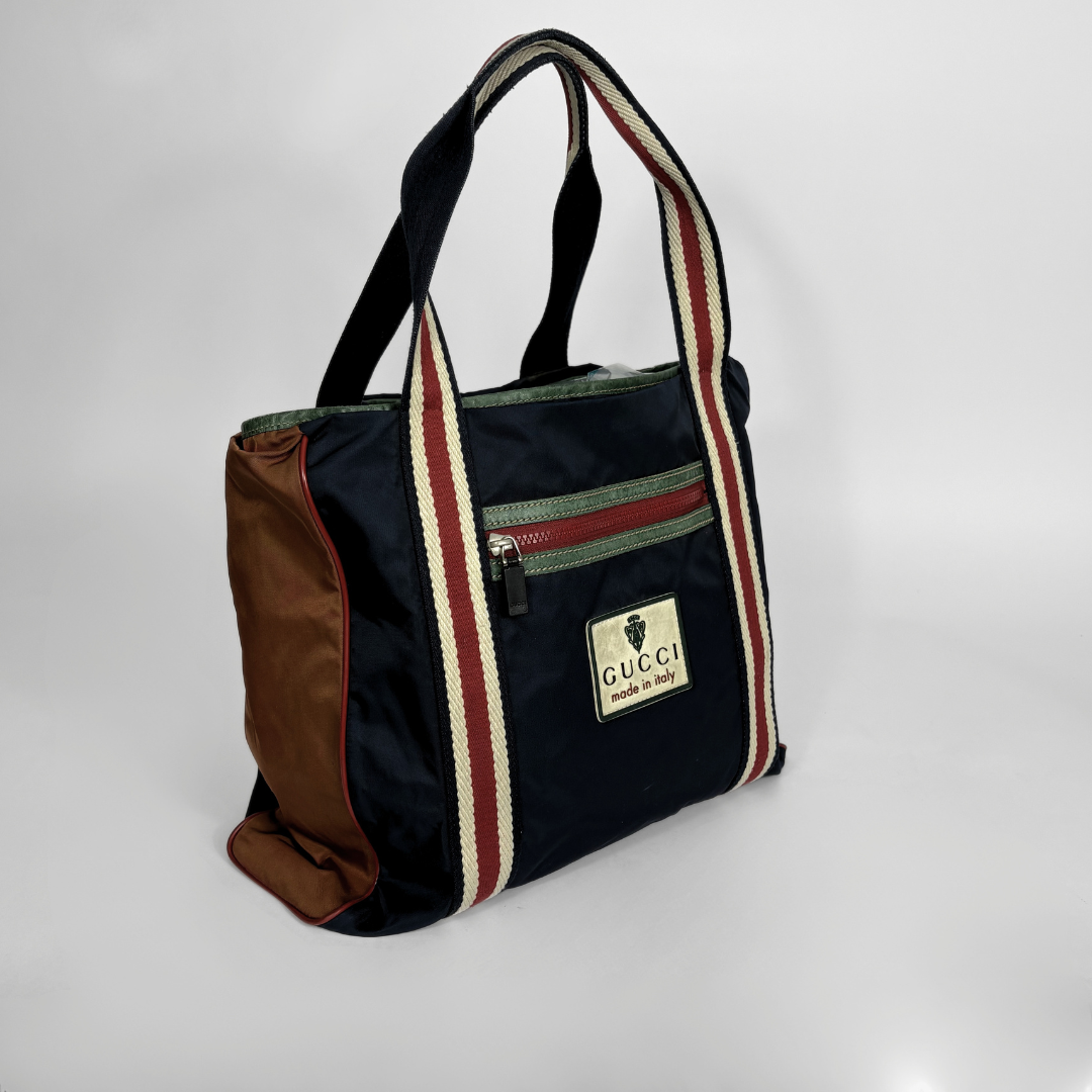 Gucci bag with striped handles on a white background