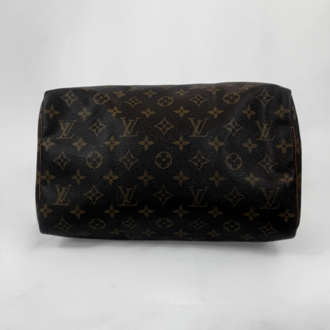 Louis Vuitton monogram canvas shoulder bag in dark brown coated canvas with tan monogram motifs, photographed against a light gray studio background.