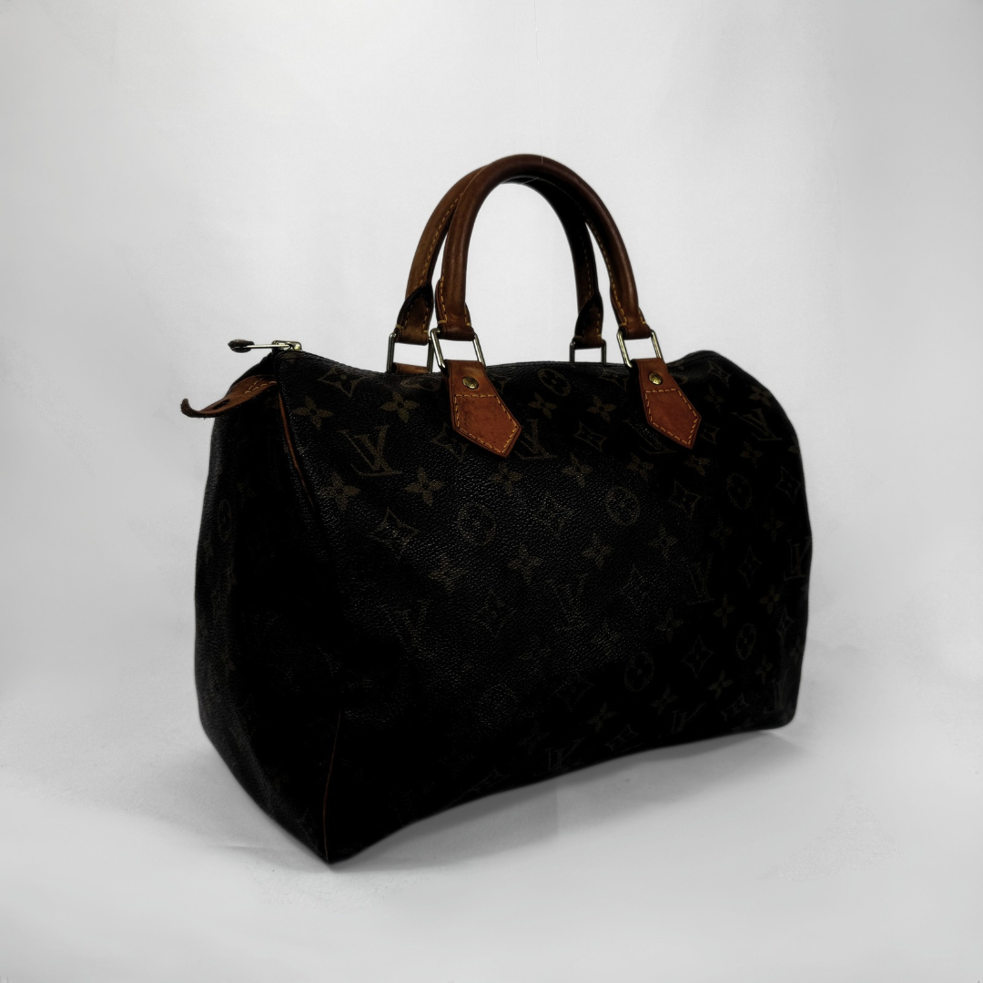 A black Louis Vuitton monogram canvas duffel bag with brown leather handles and trim, photographed on a light gray studio background.