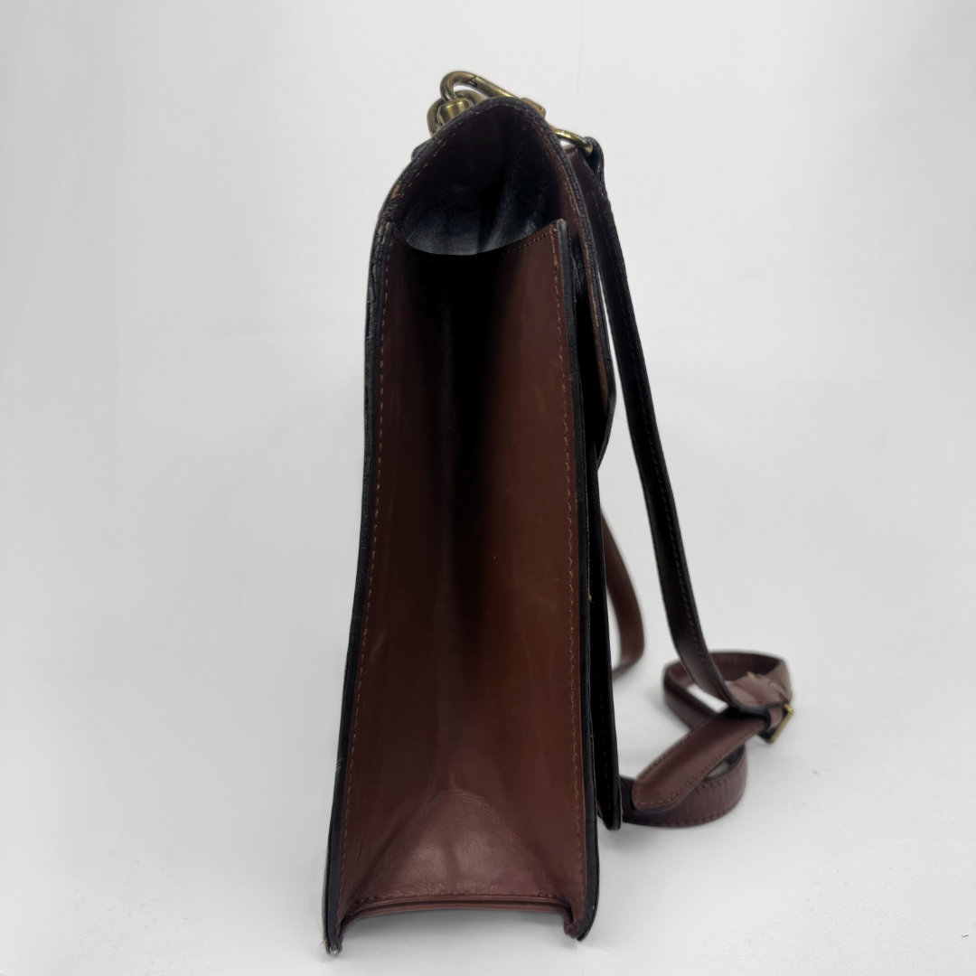 Side view of a dark brown leather shoulder bag with a matching leather strap and gold-tone hardware, photographed against a plain white background.