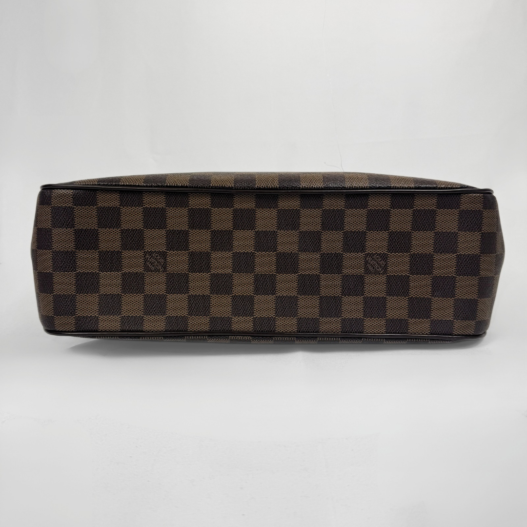 A Louis Vuitton toiletry bag in the brand's signature Damier Ebene checkered canvas, featuring a brown and black checkerboard pattern, photographed from a top-down angle on a light gray background.