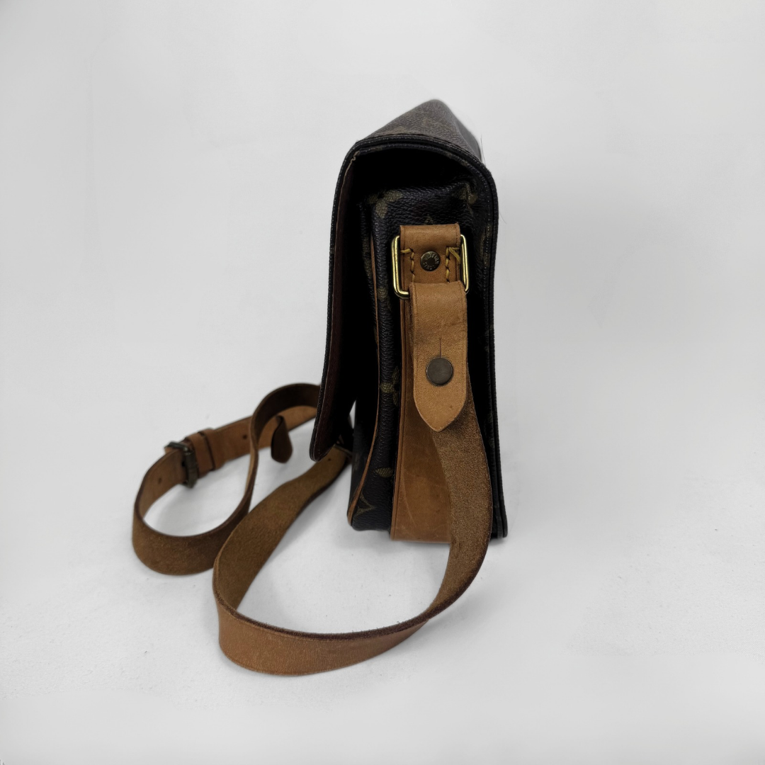 A vintage Louis Vuitton shoulder bag in brown monogram canvas with tan leather trim and strap, shown from a side profile view on a white background.