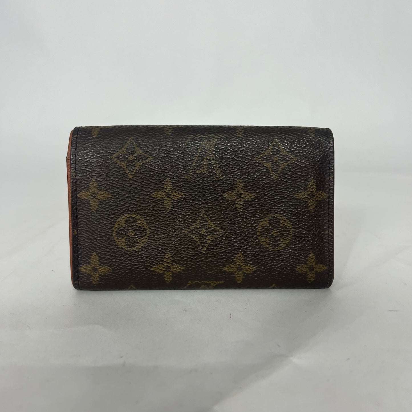 Louis Vuitton lompakko, jossa on monogrammikuvio valkoisella taustalla