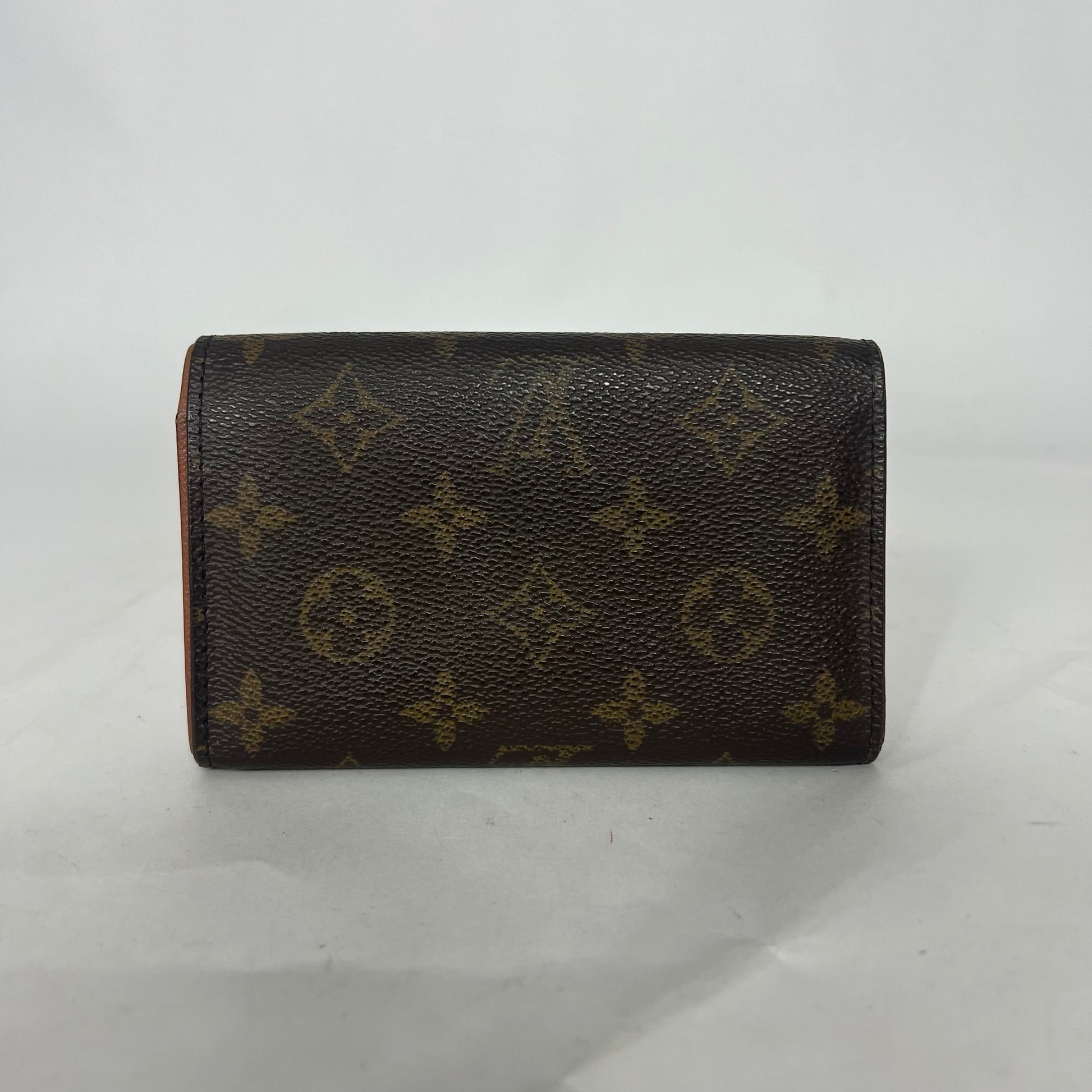 Louis Vuitton lompakko, jossa on monogrammikuvio valkoisella taustalla