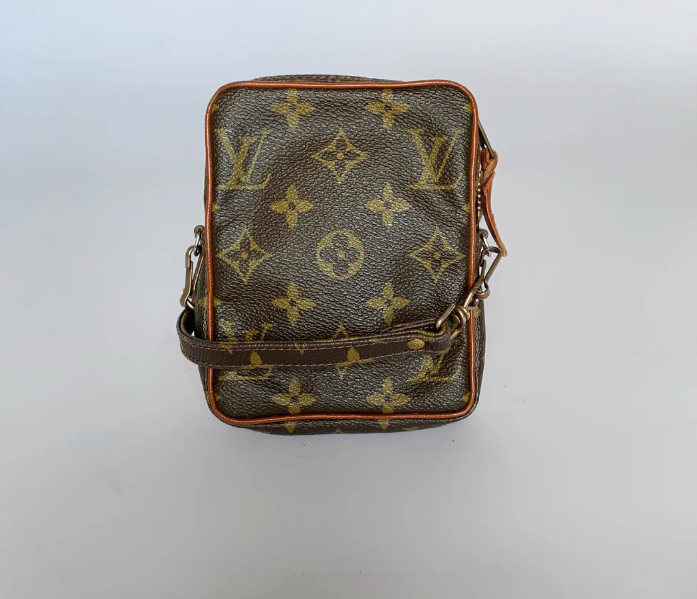 Black leather bag with brown monogram pattern on a white background