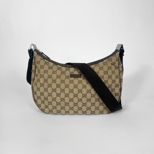 Beige handbag with black strap on a white background